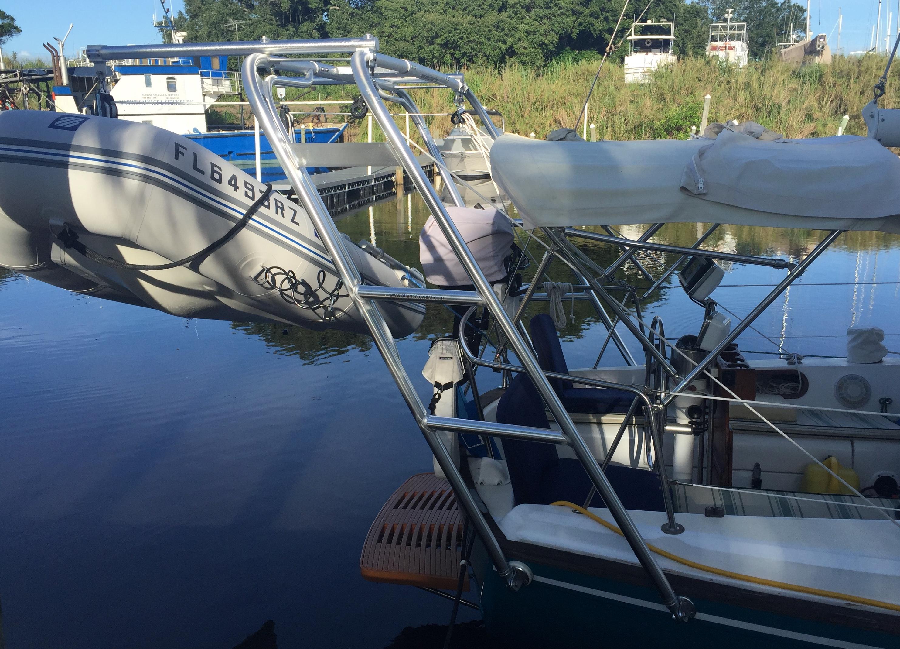 Atlantic Towers Arch installed on a boat with a dinghy, reflecting in calm water at a marina.