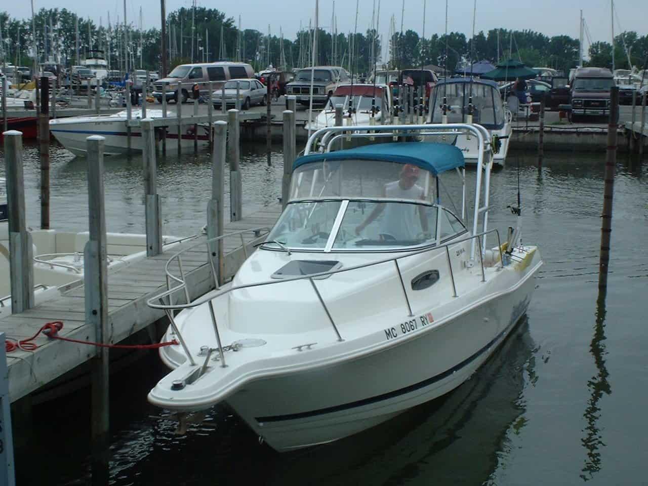 Atlantic Towers Arch installed on a Wellcraft Walkaround boat at a marina, surrounded by other boats and docks.