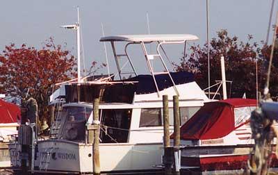 Atlantic Towers Top installed on Mainship 34 Motor Cruiser docked at marina with surrounding boats and autumn trees.