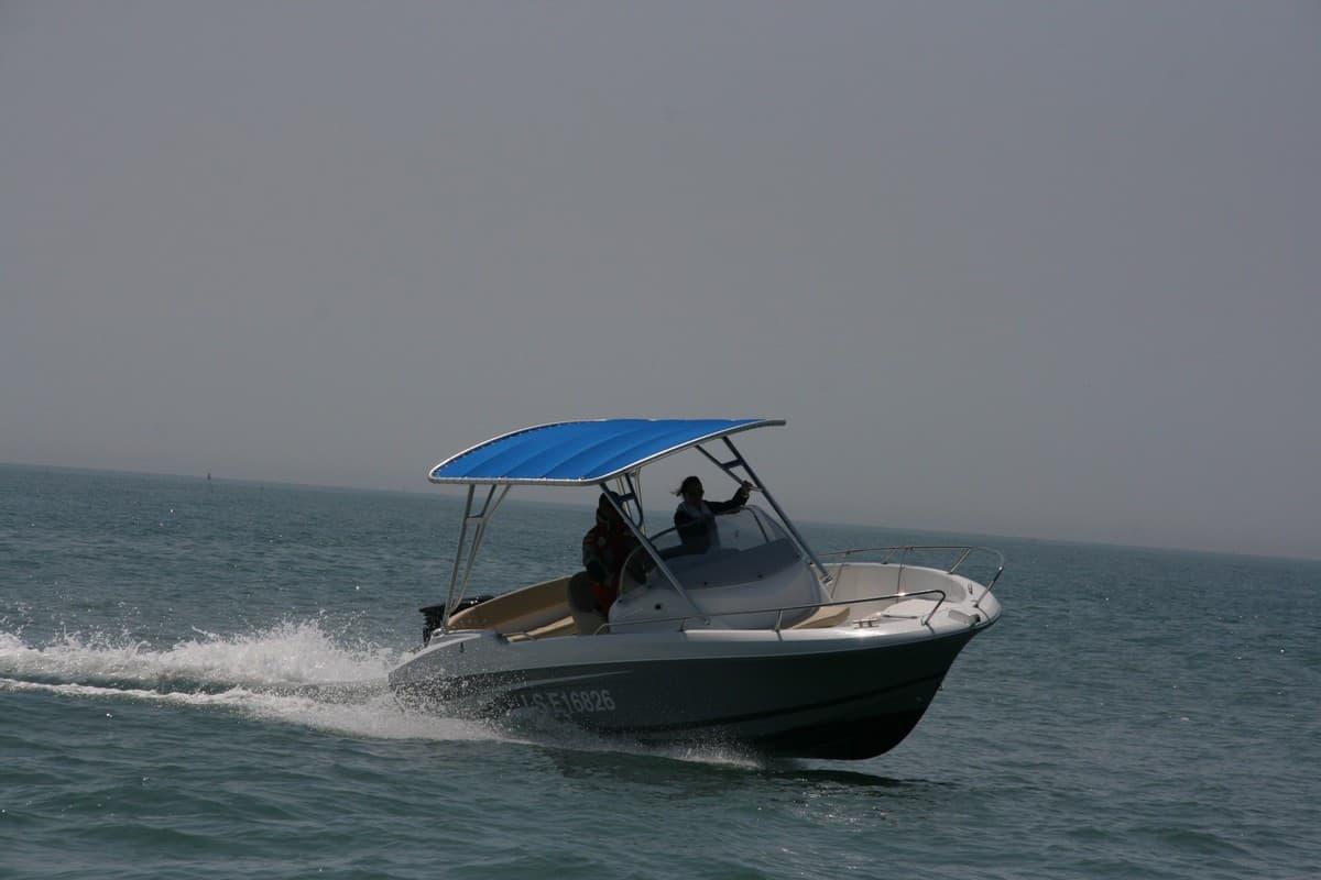 Atlantic Towers Top installed on a Beneteau Flyer 650 boat, cruising over the water with two occupants onboard.