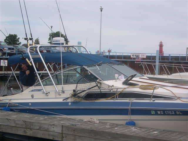 Atlantic Towers Arch installed on a Sea Ray 268 Weekender boat at a marina, with a fisherman onboard.