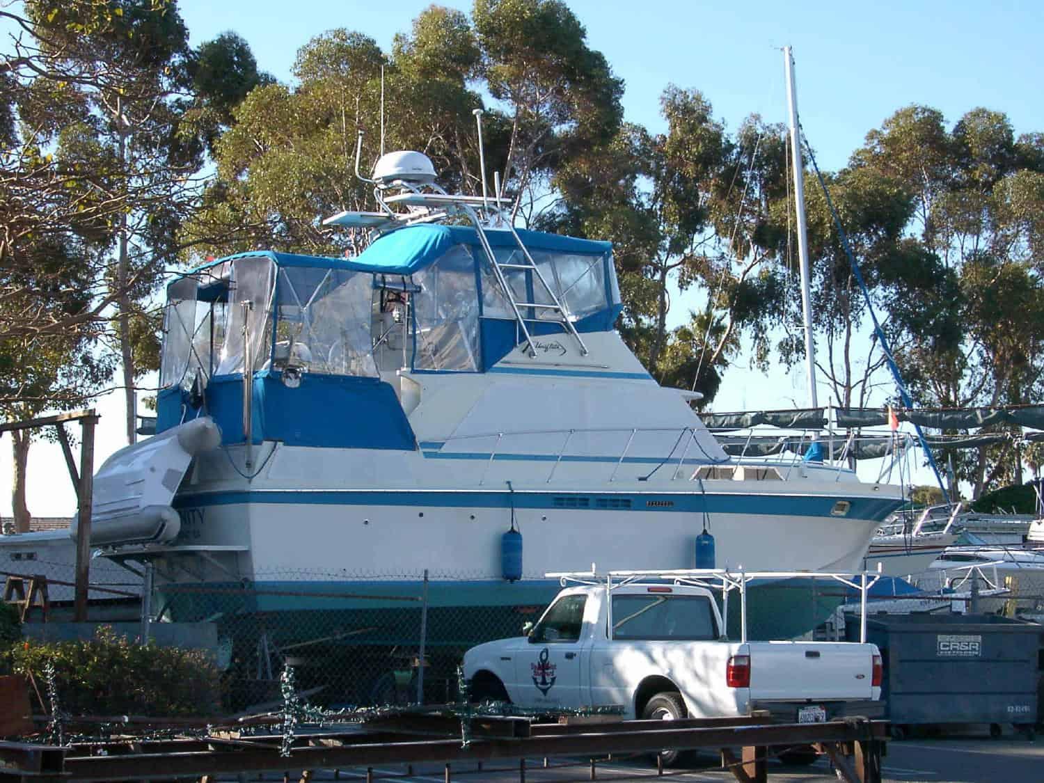 Atlantic Towers Arch installed on a Uniflite Double Cabin boat, docked near trees and other vessels.