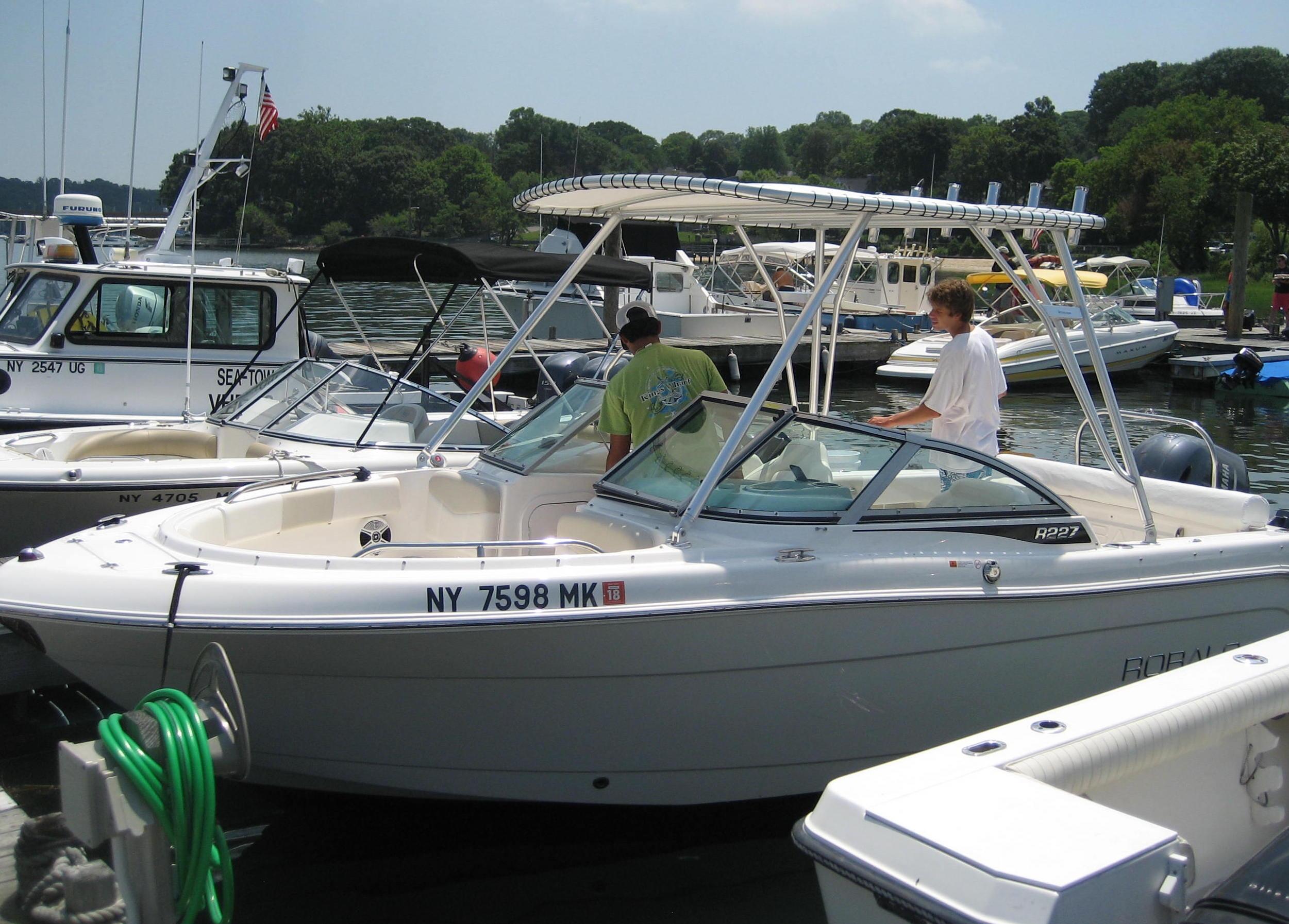 Atlantic Towers Top installed on a Robalo boat, with two people onboard at a busy marina.