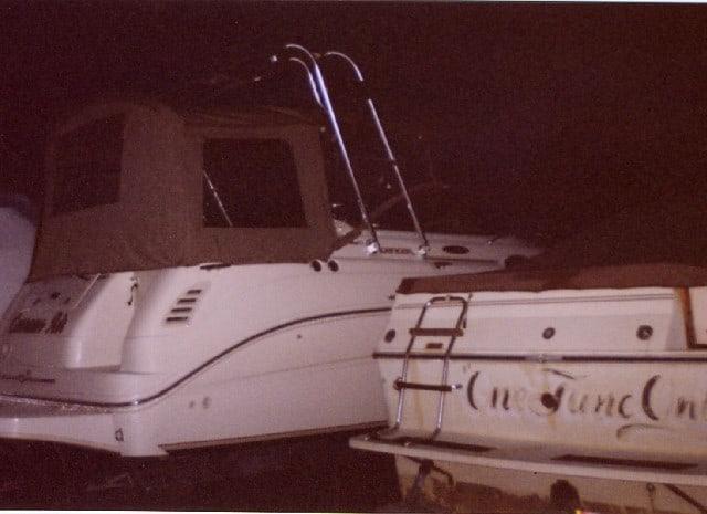 Sea Ray 260 boat with a brown canopy and Atlantic Towers arch installed, parked next to another boat at night.