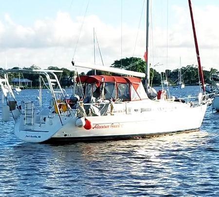 Atlantic Towers arch installed on a Beneteau sailboat anchored on calm water near a shoreline with trees.