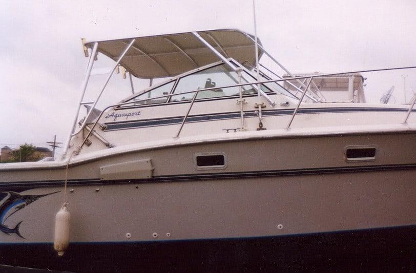 Side view of Aquasport 286XF boat with Atlantic Towers Top installed over the cockpit area under cloudy sky