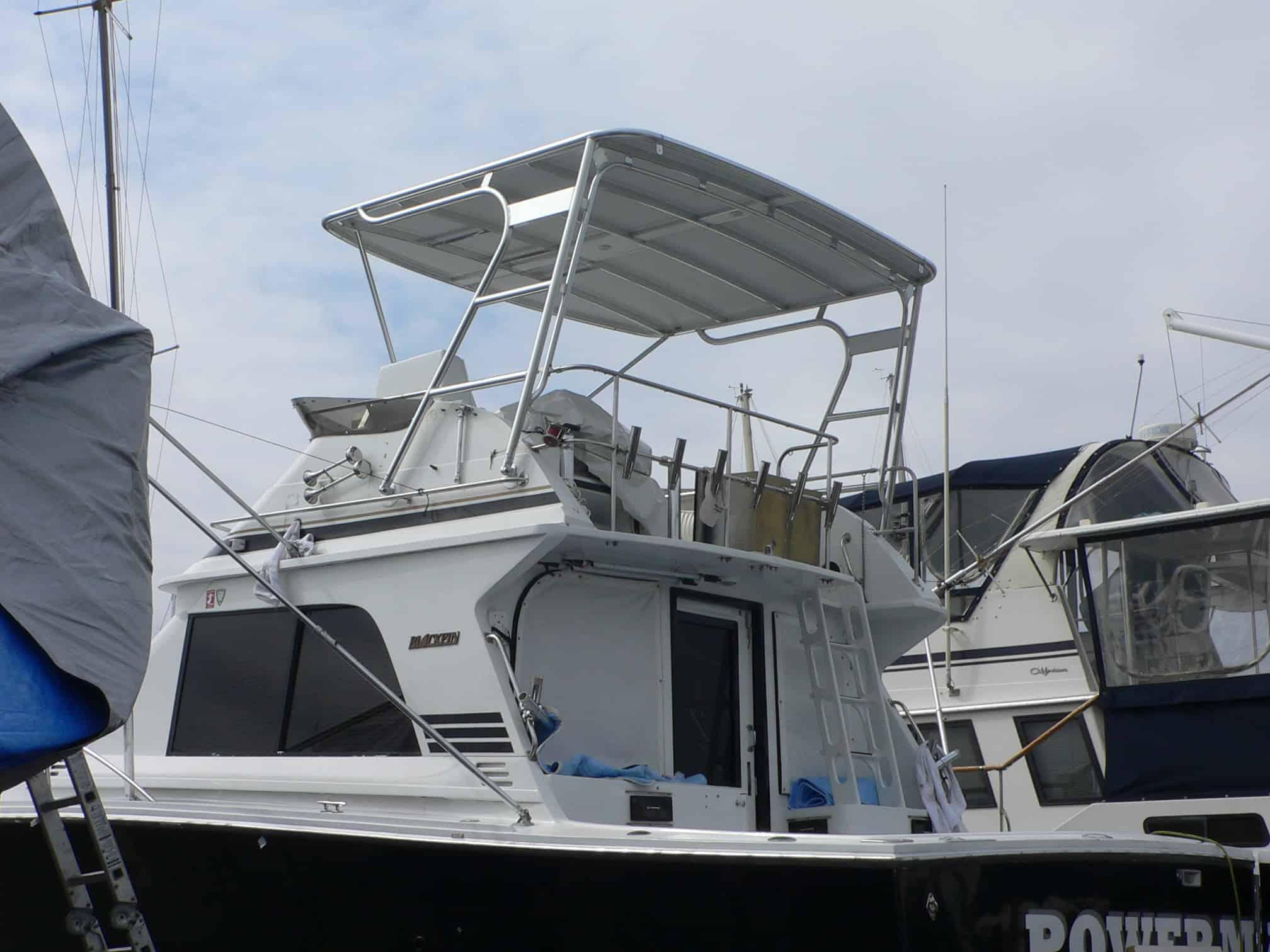 Blackfin 36/38 Convertible boat with installed Atlantic Towers Top on the flybridge, docked in a marina.