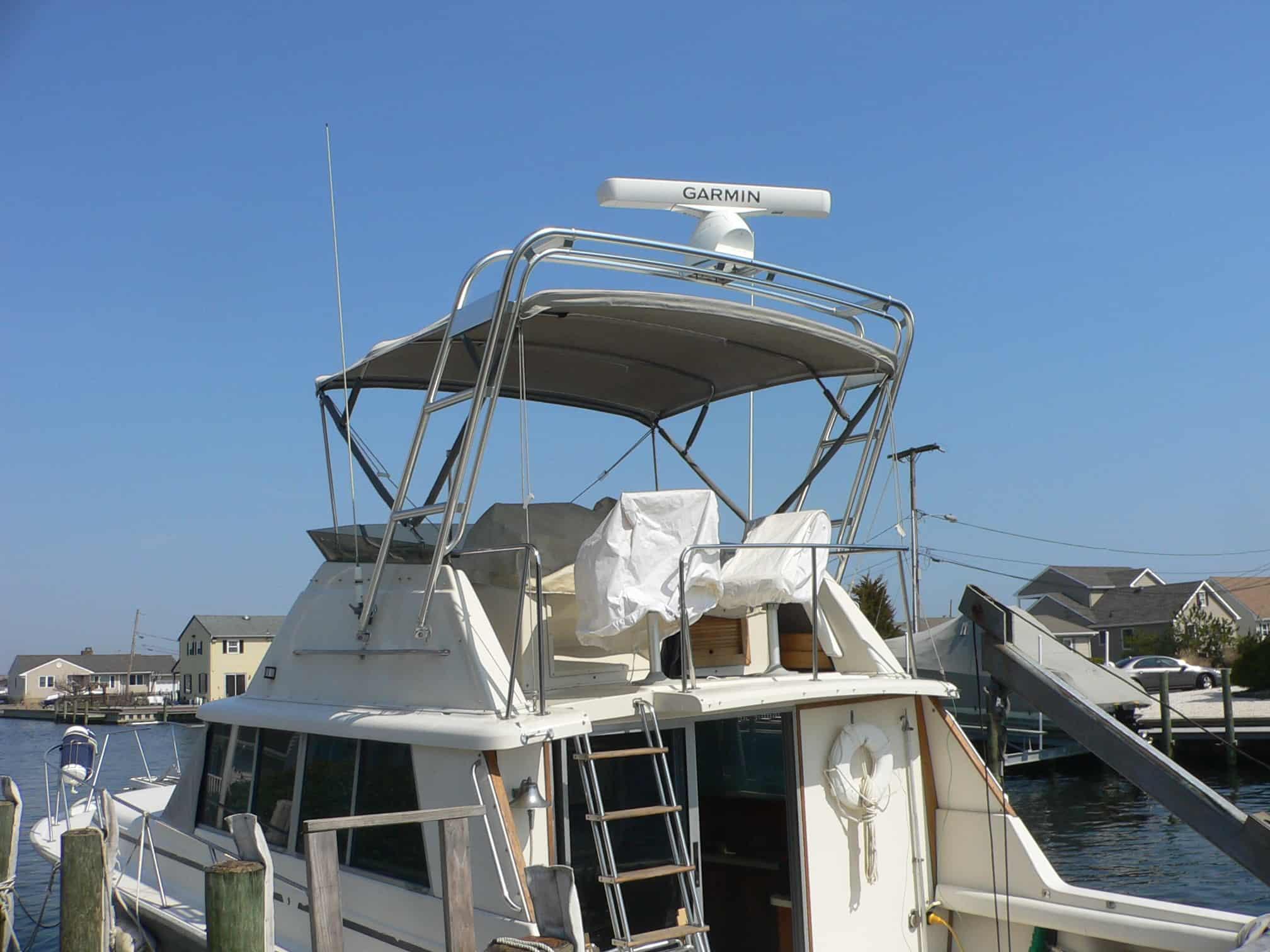 Atlantic Towers arch installed on the flybridge of a Silverton 37 Convertible boat docked at a marina.