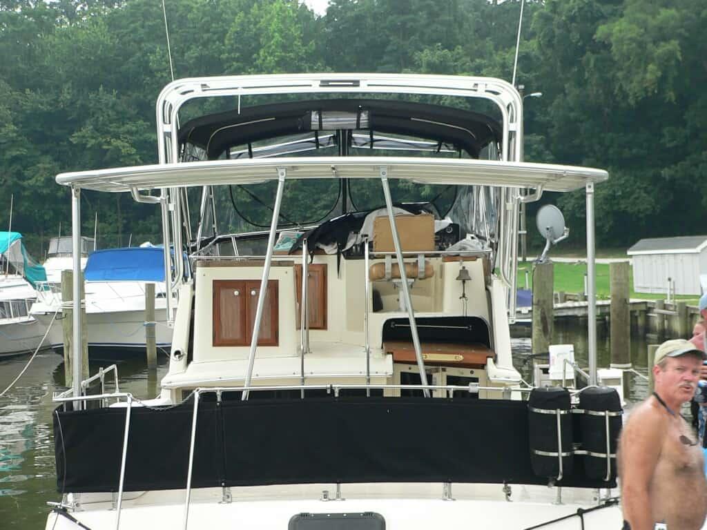 Rear view of a Carver 36 Aft Cabin boat with installed Atlantic Towers Aft Deck Top in a marina setting.