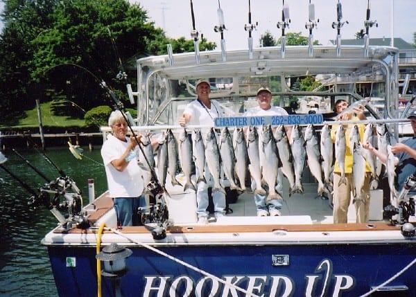 Men holding a large catch of fish on a Trojan 10 Meter boat featuring an Atlantic Towers Top.