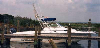 Atlantic Towers Arch installed on a Wellcraft 238 Coastal boat docked near wooden piers on calm water.