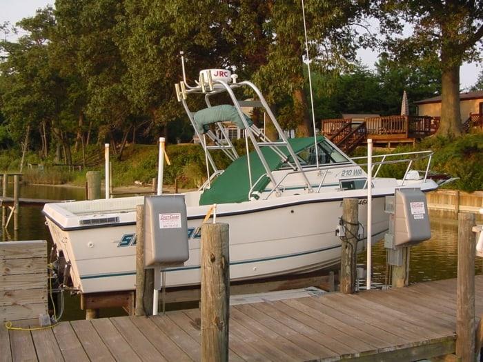 Atlantic Towers Arch installed on a Sea Pro 210 W/A boat docked at a marina with wooden pilings.