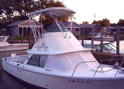 Atlantic Towers Top installed on a Bertram 31 Flybridge Cruiser docked at a marina during sunset.