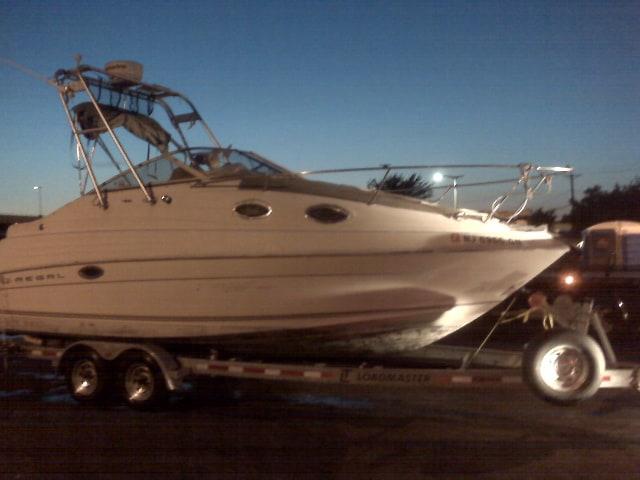Atlantic Towers Arch installed on a Regal 242/2460/2465 cruiser boat shown in a marina with calm water.