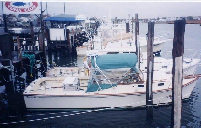 Atlantic Towers Arch installed on a Fortier Boats 26 Cuddy moored at a marina with other boats nearby.