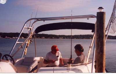 Atlantic Towers Arch installed on a Chaparral 252 Sunesta boat with two people fishing on board near a dock.