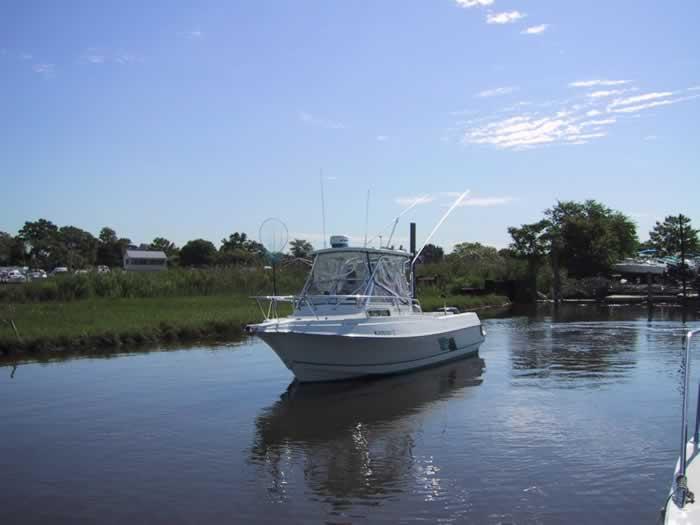 Atlantic Towers Accessories installed on a fishing boat navigating a calm waterway under a clear blue sky.