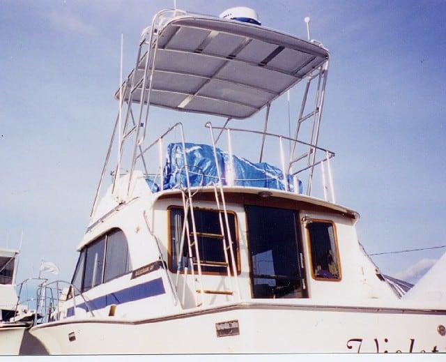 Atlantic Towers Arch installed on a Bertram boat, featuring a raised top with protective cover and a ladder.