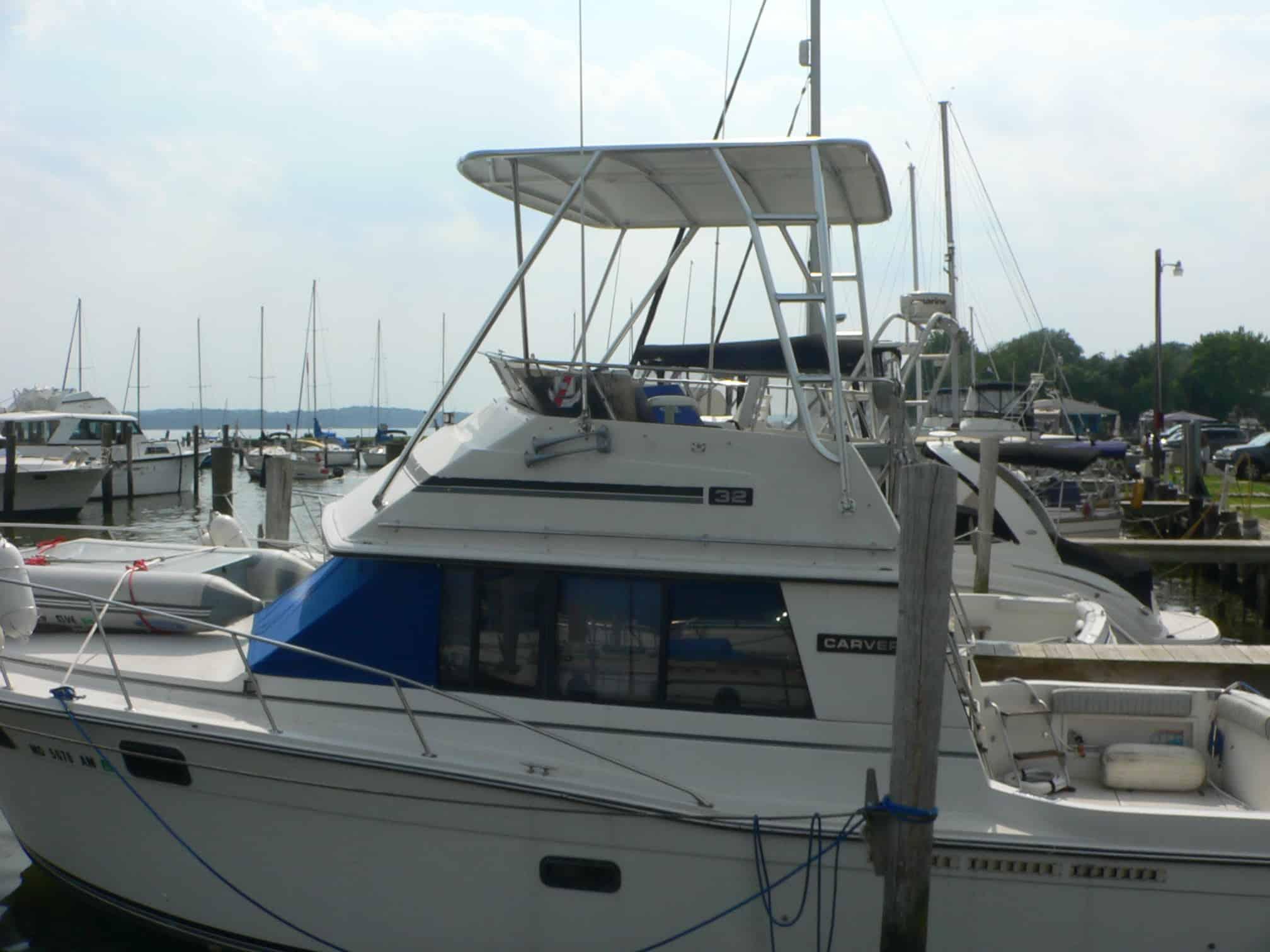 Atlantic Towers Top installed on a Carver 32 Convertible boat at a marina, with surrounding vessels visible.