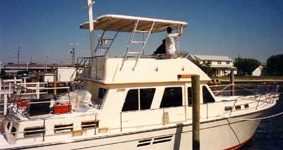 Atlantic Towers Top installed on a Sabreline 43 boat, featuring a person adjusting the canopy on the upper deck.