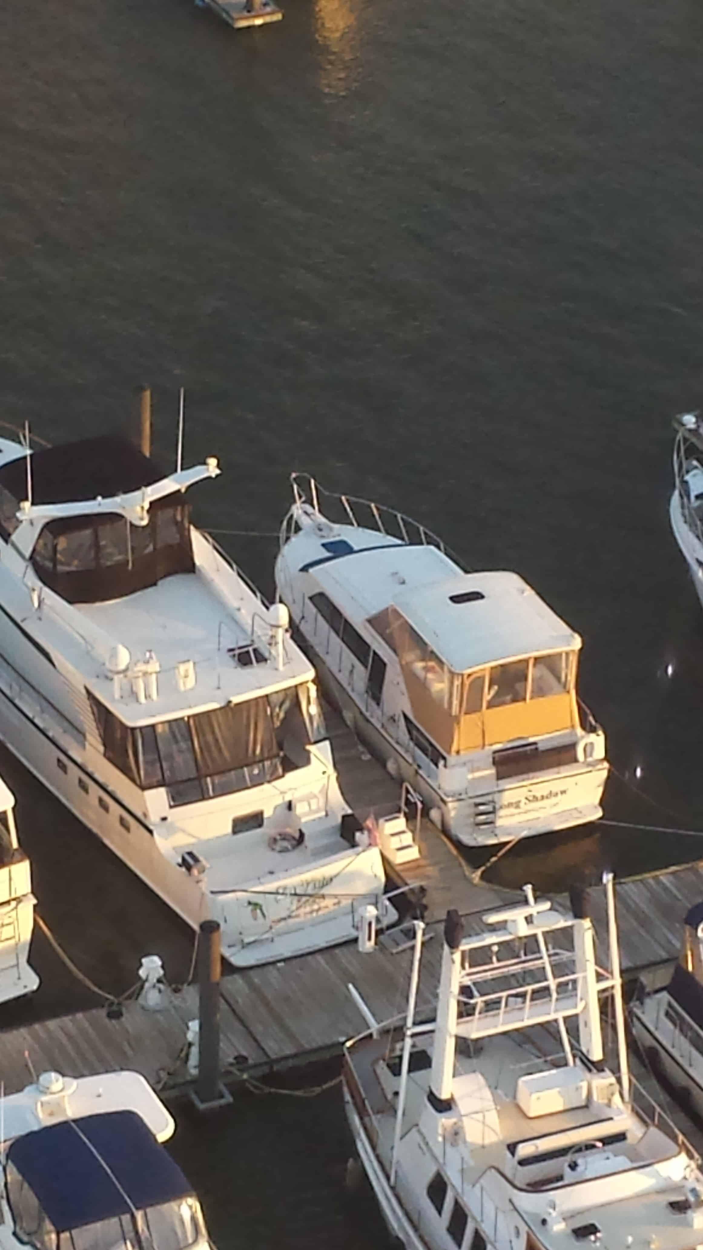 Chris Craft boat docked at marina with Atlantic Towers Top installed, surrounded by other boats on calm water.