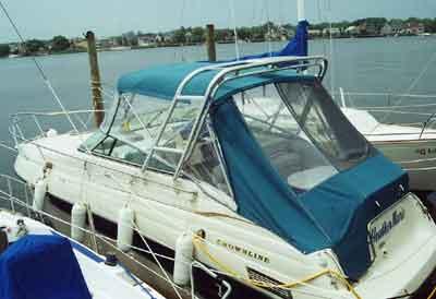 Atlantic Towers arch installed on a Crownline 268 CR boat with a blue canvas cover docked at a marina.