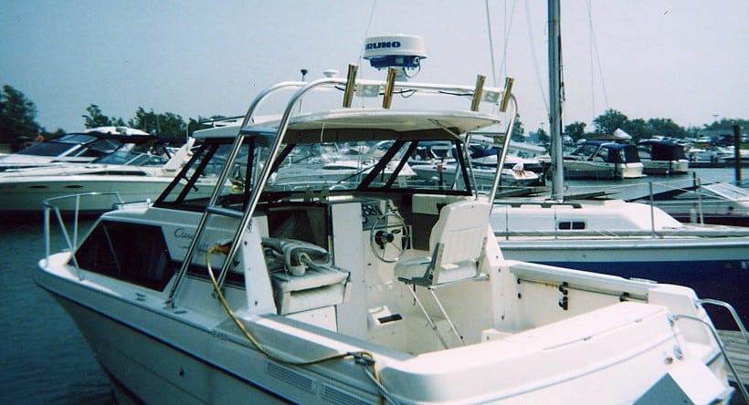Atlantic Towers arch installed on a white Bayliner 2452 Ciera boat docked at a marina with various other boats in the background.