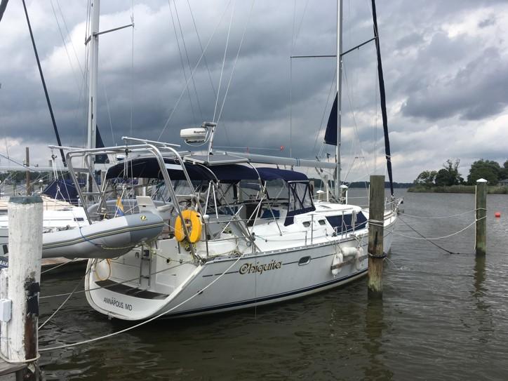 Atlantic Towers Arch installed on a Jeanneau sailboat docked at a marina under cloudy skies.