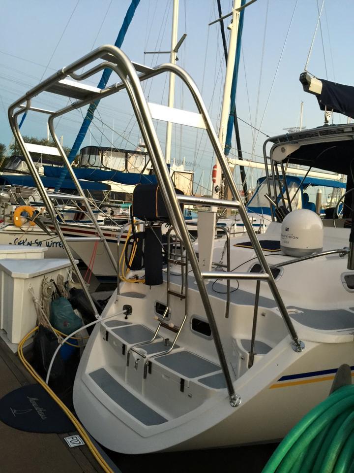Atlantic Towers arch installed on the stern of a Hunter sailboat docked in a marina with other boats nearby.