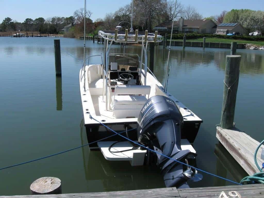 Atlantic Towers T-Top mounted on a Chris Craft boat docked in still water, surrounded by trees and homes.
