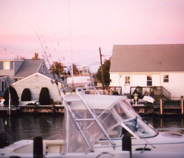 Atlantic Towers arch installed on a Mako 233 Walkaround boat docked near waterfront houses at dusk.
