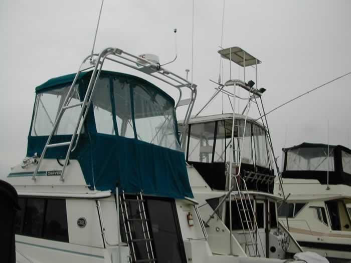 Atlantic Towers Arch installed on a Carver boat with a green canvas enclosure and ladder on the upper deck.