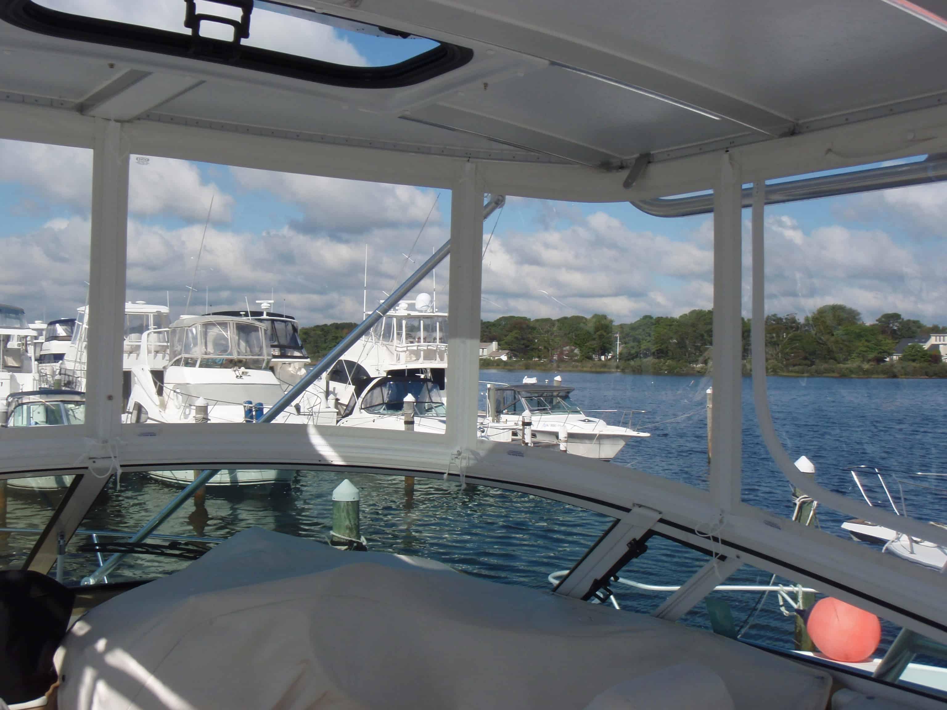 View from inside a Carver 350 Mariner boat cockpit with installed Atlantic Towers Top, boats docked outside on a calm day.