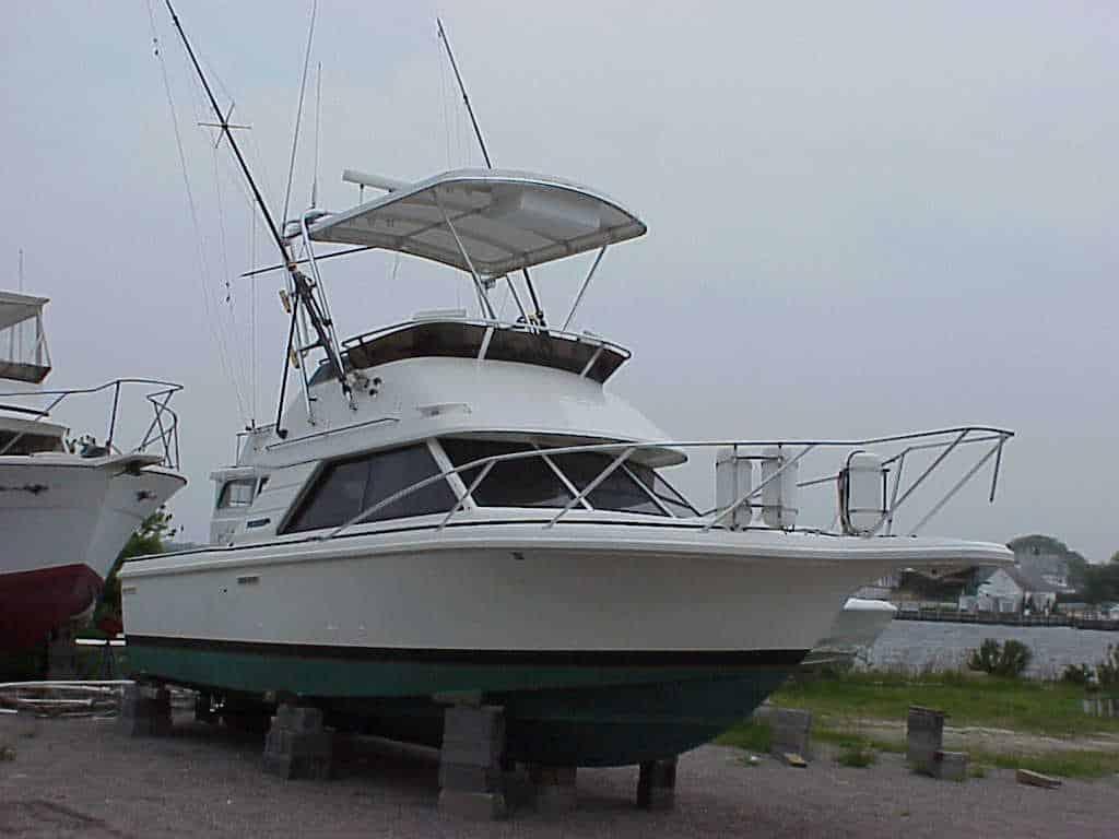 Atlantic Towers Top installed on a Phoenix 29 SFX Convertible boat, moored on blocks near water.