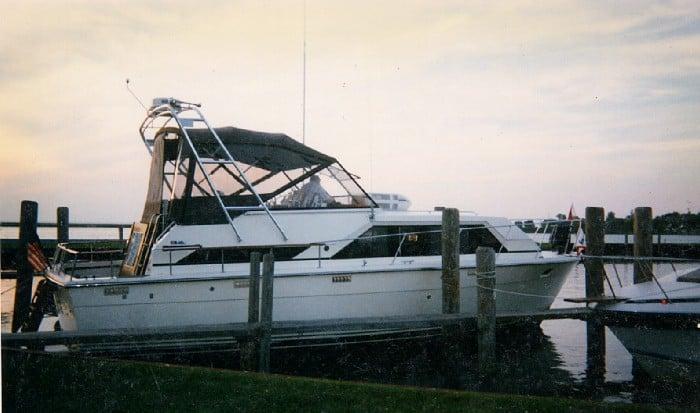 Atlantic Towers Arch installed on a Trojan Tri-Cabin boat docked at a marina during sunset.