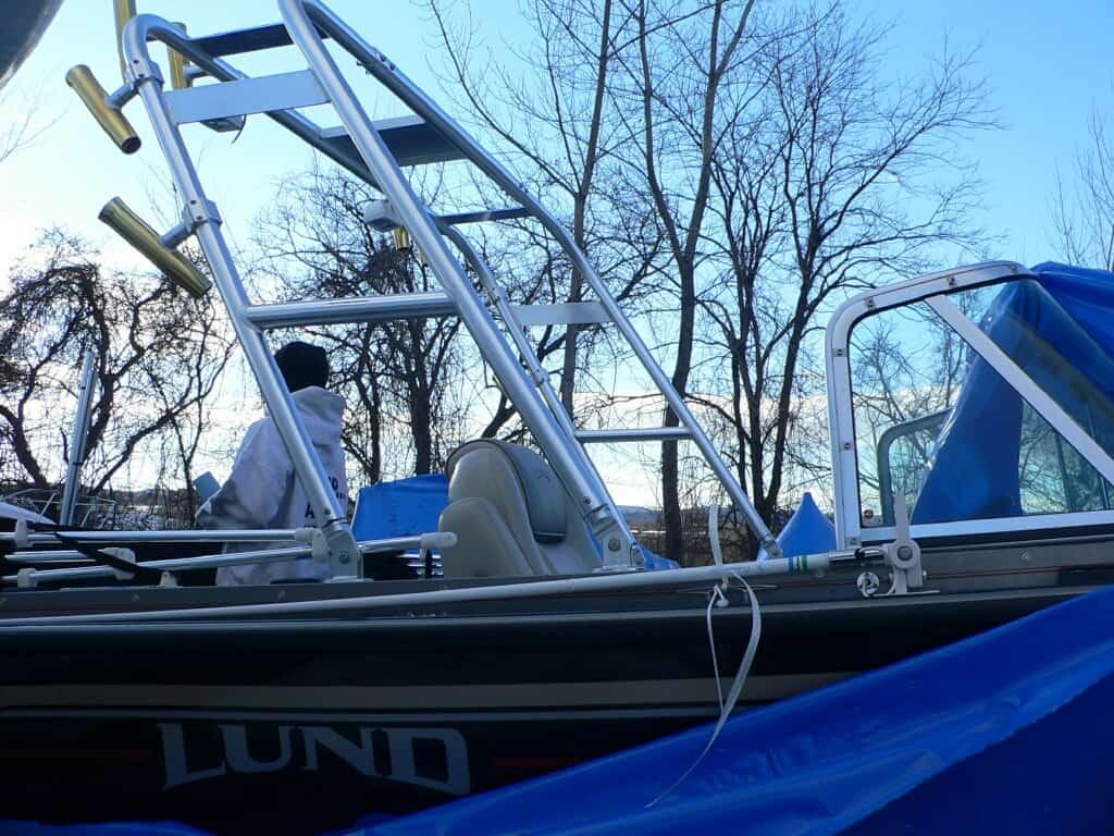 Atlantic Towers Arch installed on a Lund 2110 Baron Magnum boat with visible rod holders and seating under clear sky.
