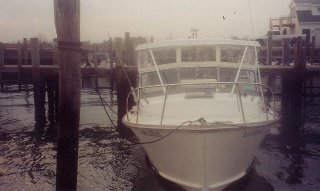 Front view of a Fortier Boats 26 Cuddy boat docked with an installed Atlantic Towers Top frame on the roof.