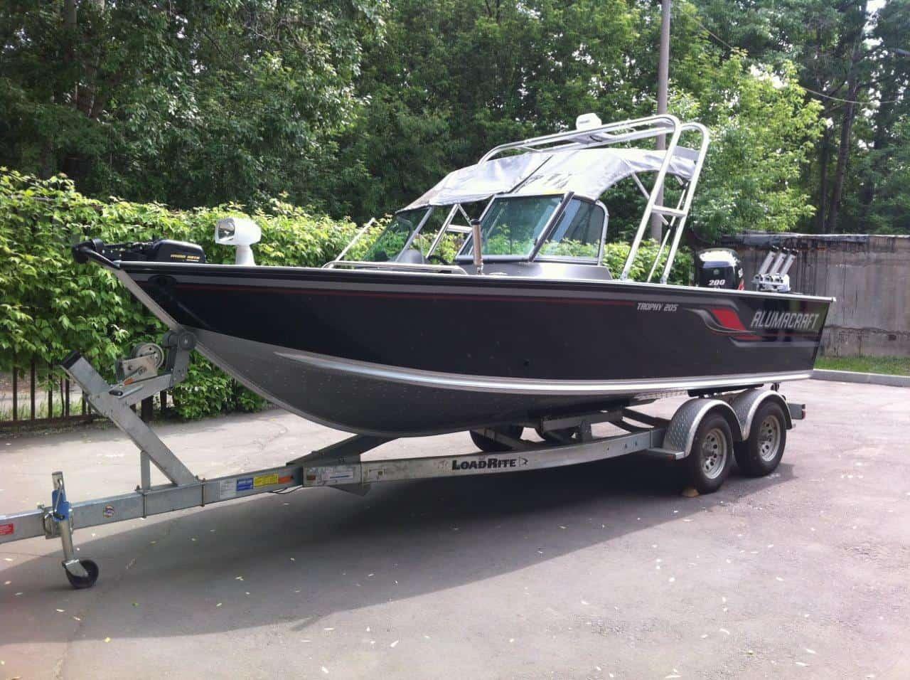 Atlantic Towers arch installed on an Alumacraft 205 Trophy boat, parked in a green outdoor setting.